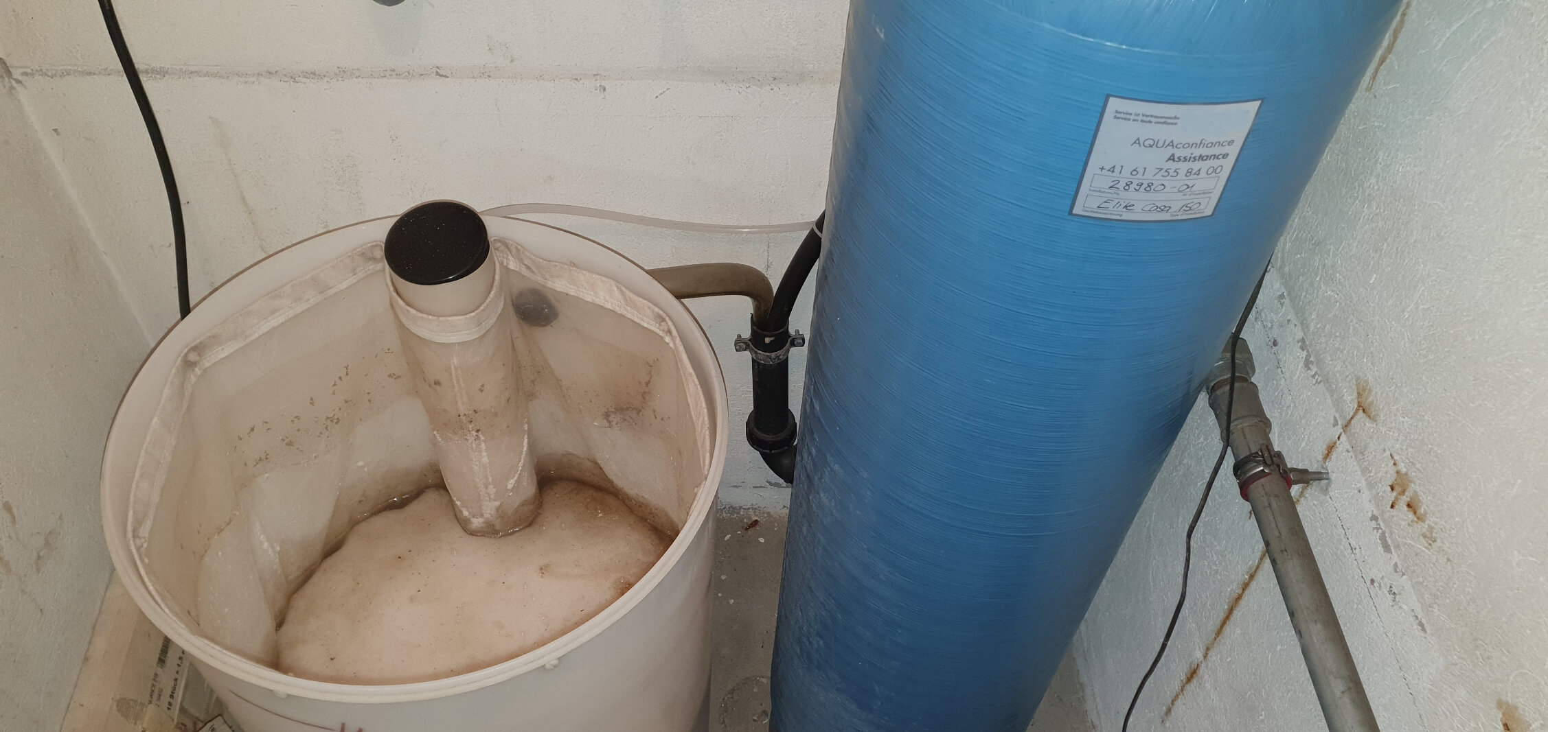 Grande plano de um recipiente de sal sujo num descalcificador de água - ineficiente e anti-higiénico. A Evodrop oferece-lhe uma alternativa sustentável sem sal.